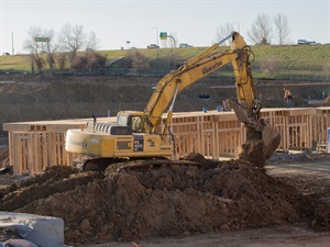 Construction excavator on mound of dirt