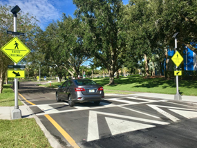 Photo of car driving over a raised crosswalk